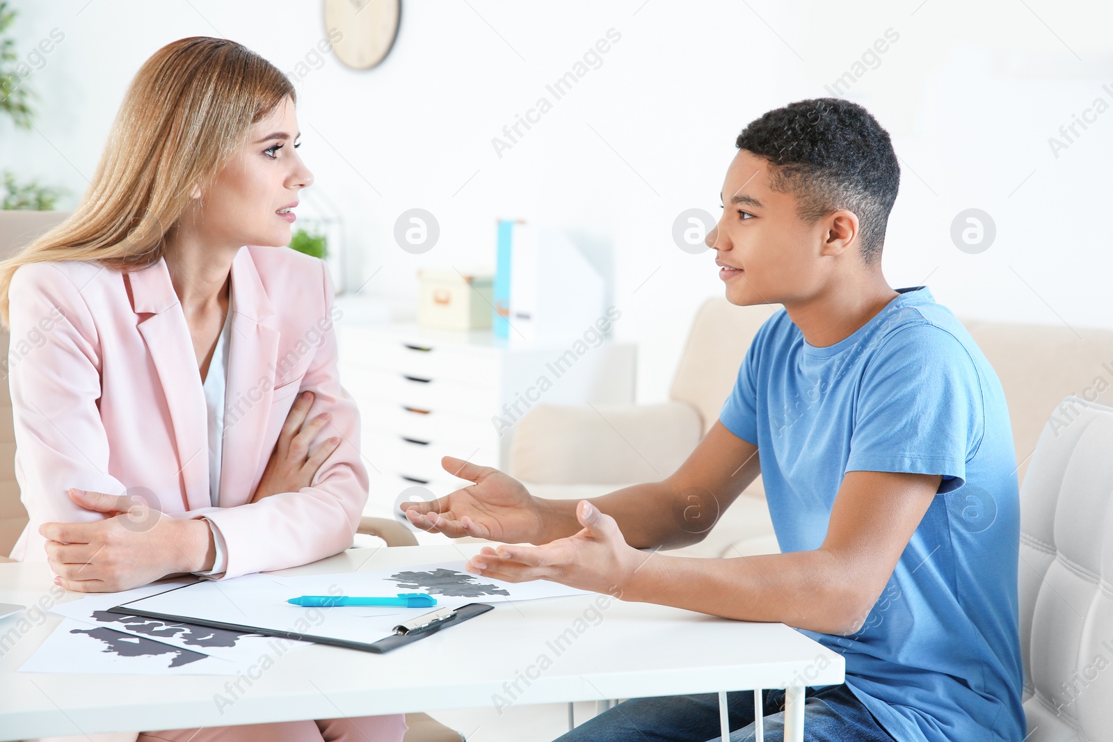 Photo of Female psychologist working with African American teenage boy in office