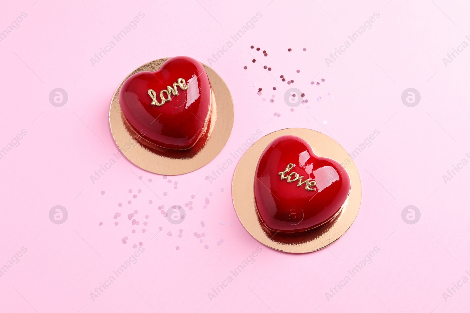 Photo of St. Valentine's Day. Delicious heart shaped cakes on light pink background, flat lay