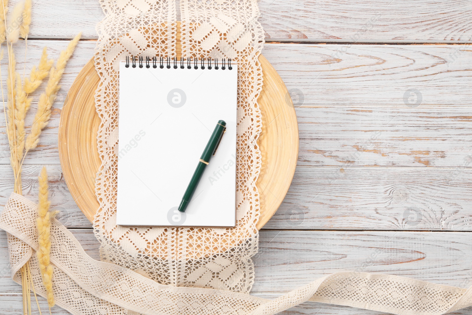 Photo of Guest list. Notebook, pen, spikelets and lace ribbons on wooden background, flat lay. Space for text