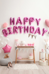 Phrase HAPPY BIRTHDAY made of pink balloon letters in decorated room