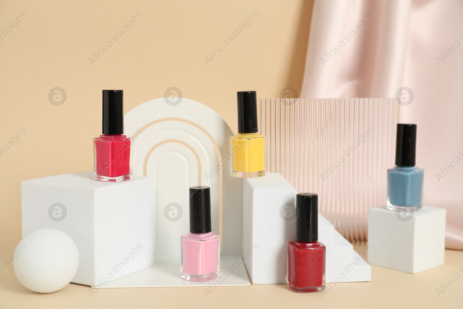 Photo of Stylish presentation of nail polishes on beige background