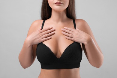 Woman with beautiful breast on light grey background, closeup