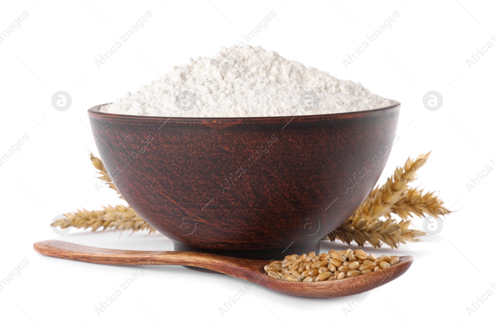 Photo of Organic flour in bowl, spoon with grains of wheat and spikelets on white background