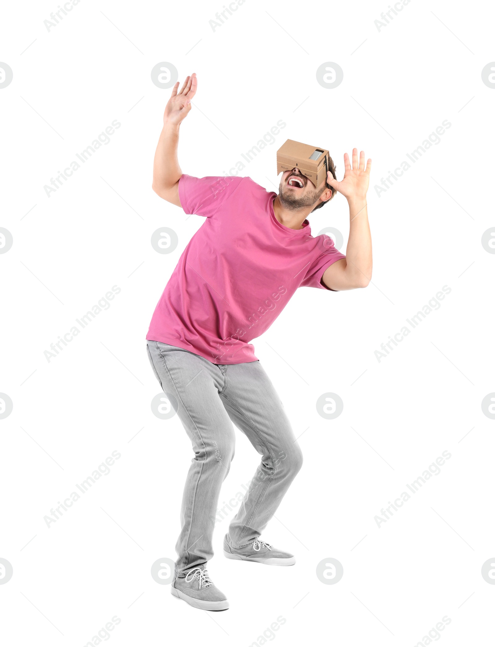 Photo of Young man using cardboard virtual reality headset, isolated on white