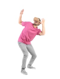 Young man using cardboard virtual reality headset, isolated on white