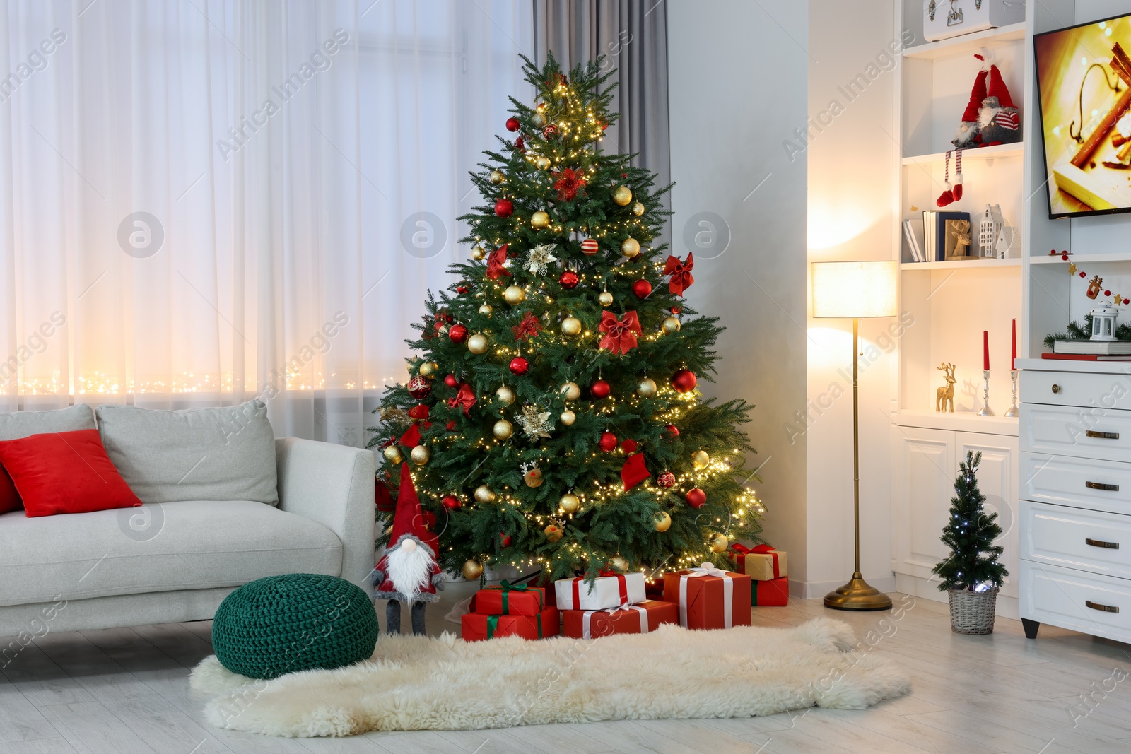 Photo of Beautiful Christmas tree, gift boxes and festive decor in living room. Interior design