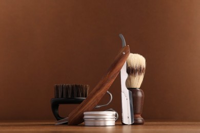 Photo of Moustache and beard styling tools on wooden table