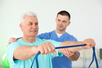 Photo of Professional physiotherapist working with senior patient in rehabilitation center