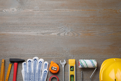 Flat lay composition with different construction tools on wooden background. Space for text