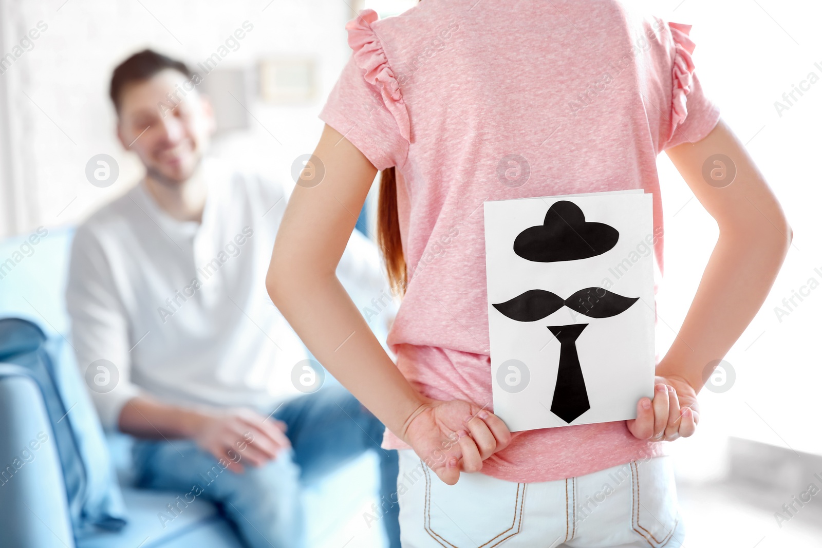 Photo of Little girl greeting her dad with Father's Day at home