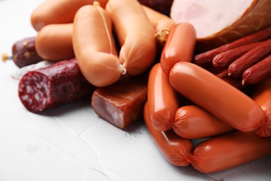 Different types of sausages on light textured table, closeup. Space for text