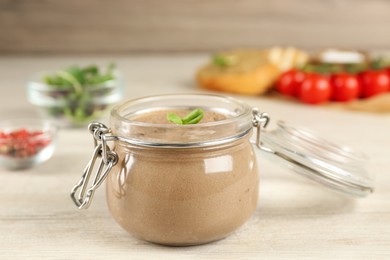 Glass jar with delicious liver pate on white wooden table, closeup