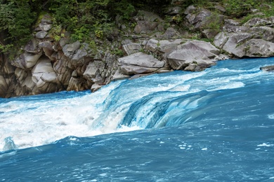 Mountain river flowing along rocky banks in wilderness