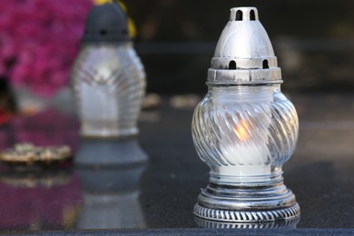 Photo of Grave lanterns on granite surface in cemetery, space for text