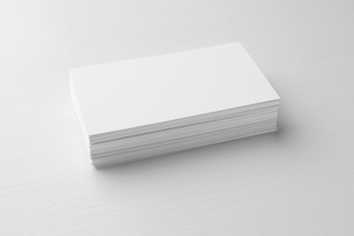 Photo of Stack of blank business cards on white table. Mockup for design