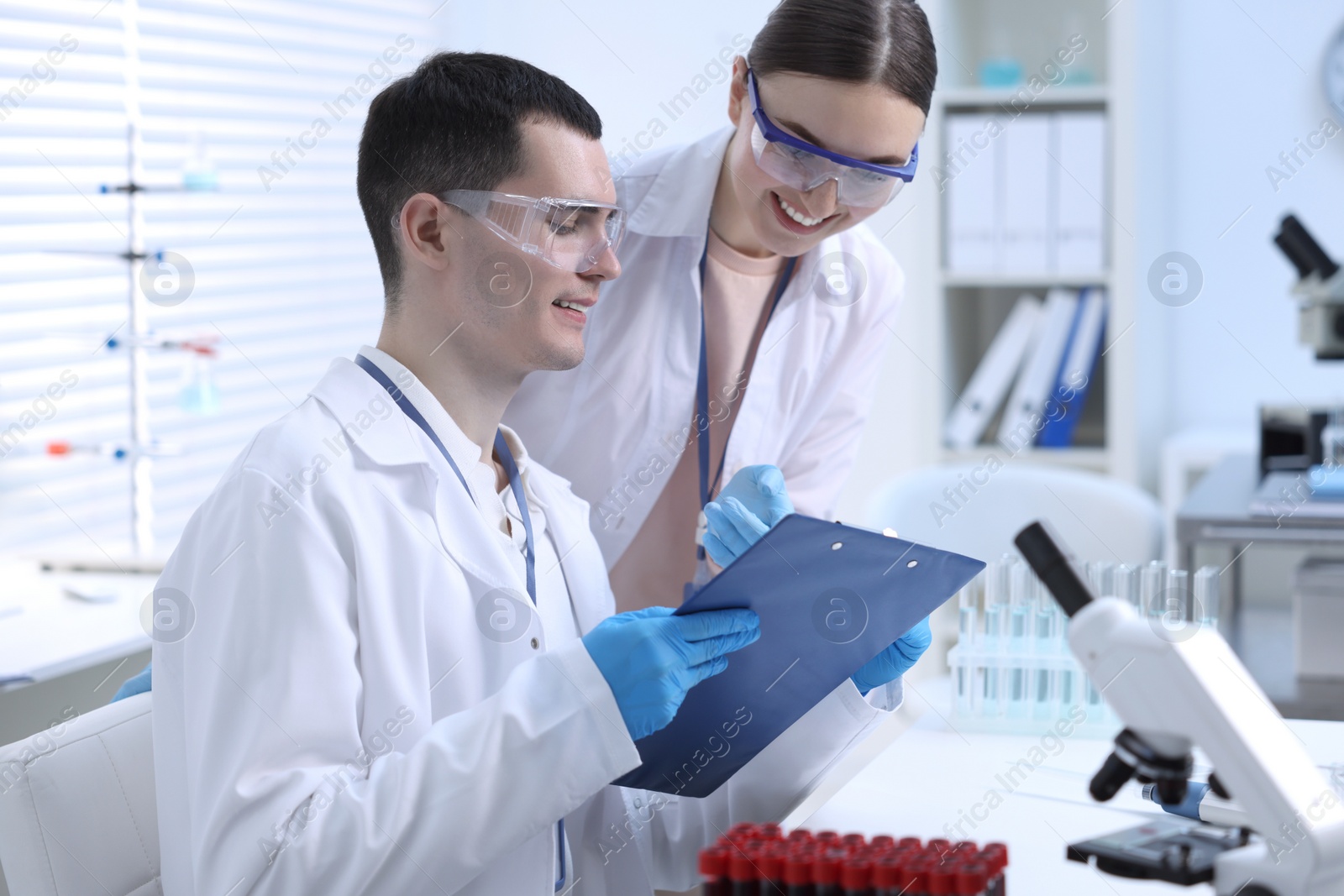 Photo of Scientists working with laboratory test form at table indoors