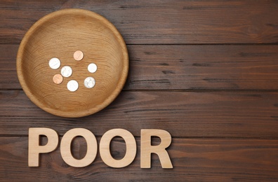 Photo of Plate with coins, word POOR and space for text on wooden background, top view