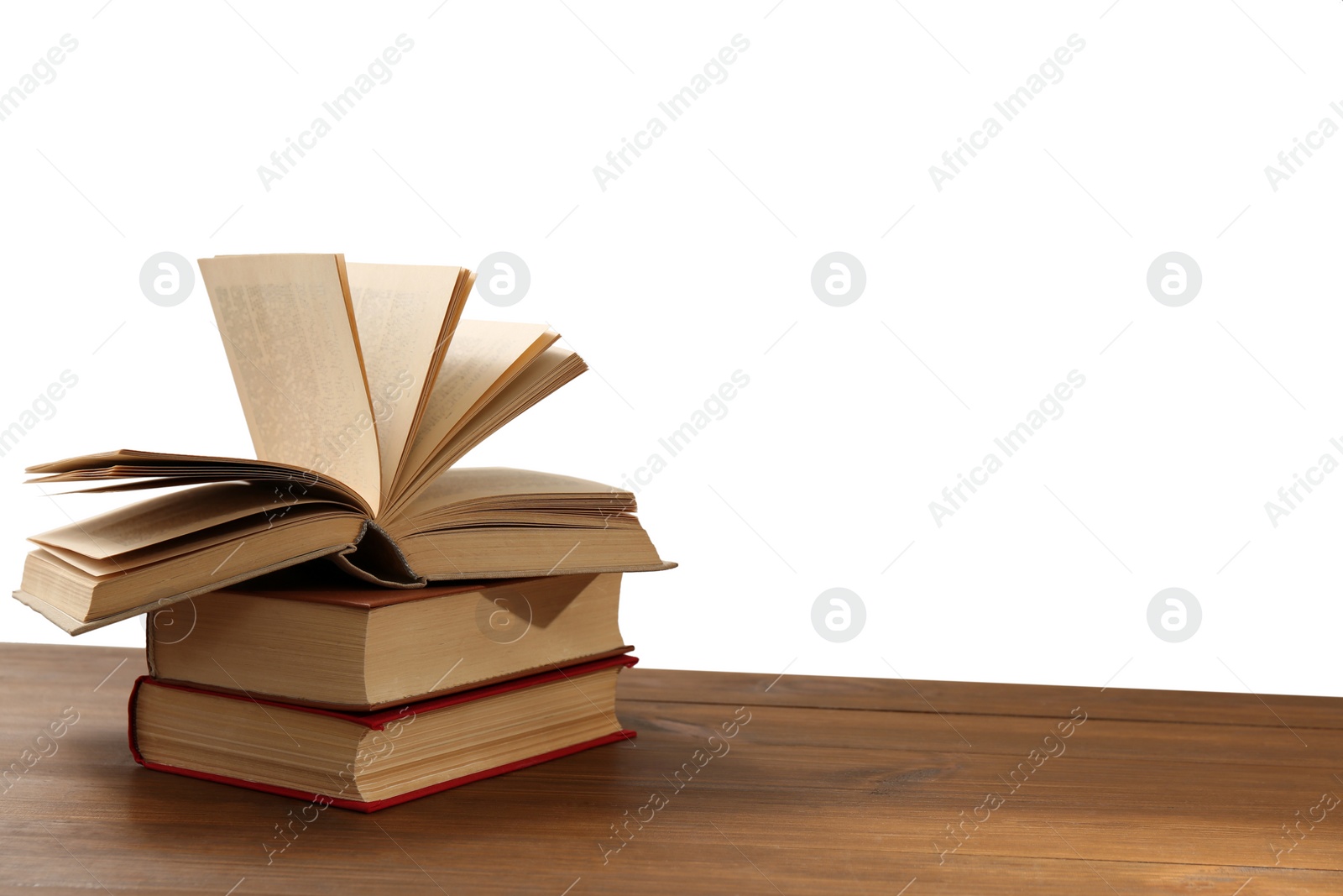 Photo of Stack of books on wooden table against white background. Library material