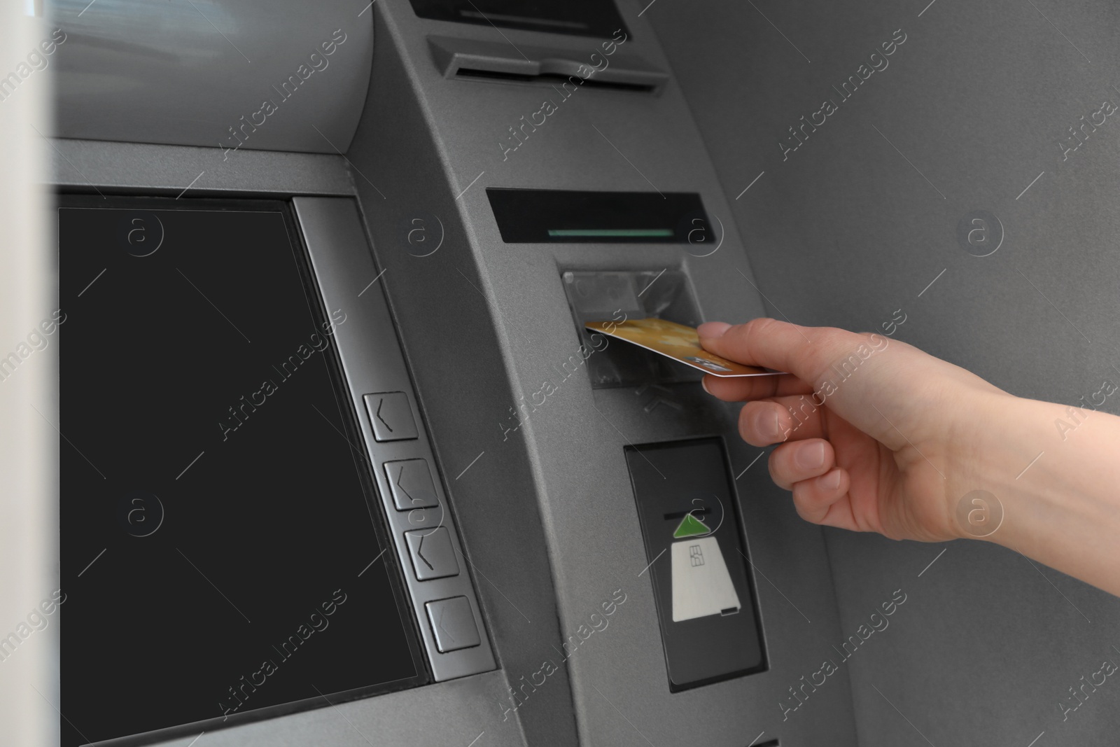 Photo of Woman inserting credit card into cash machine outdoors, closeup