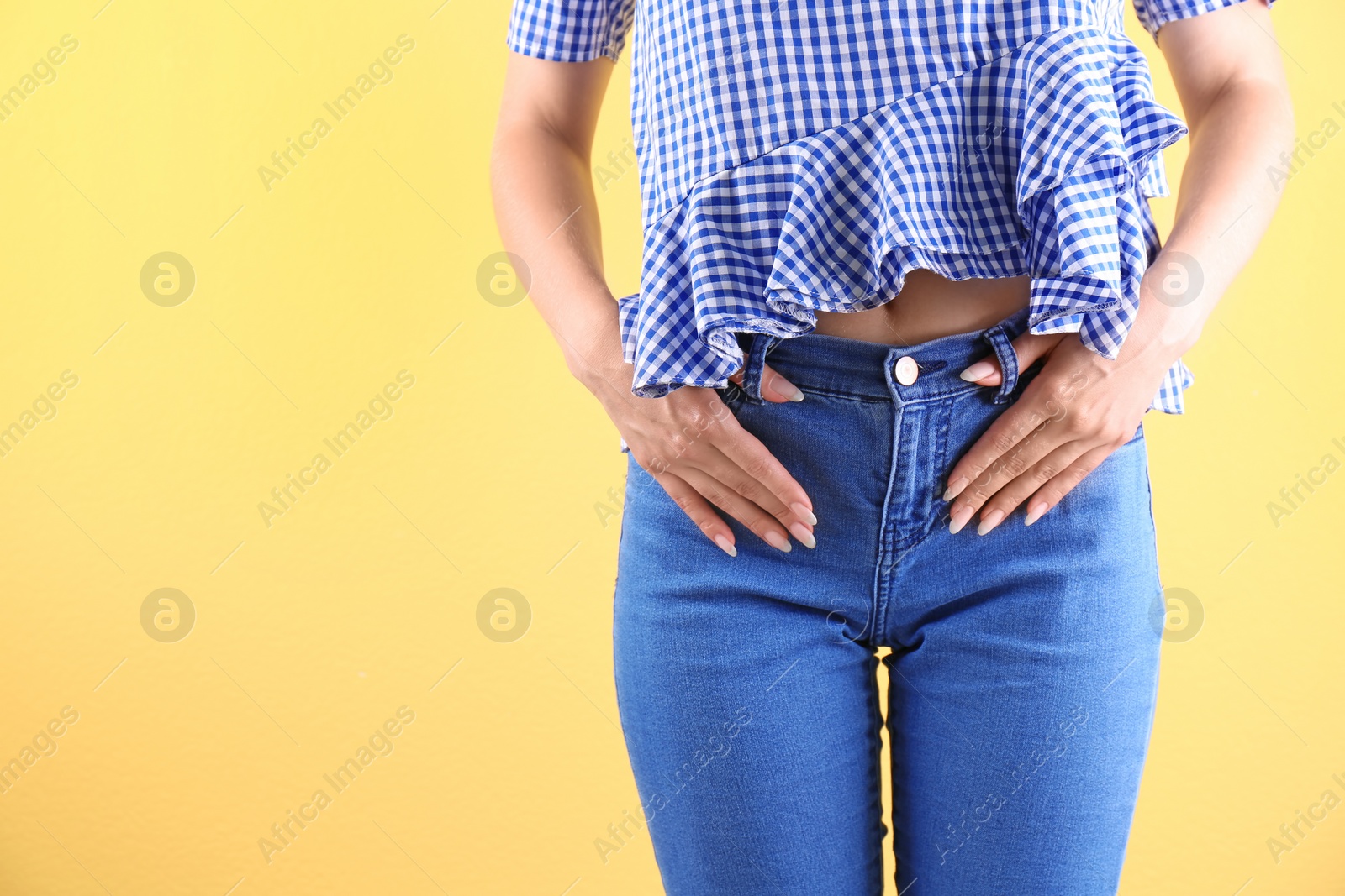 Photo of Woman in stylish blue jeans on color background