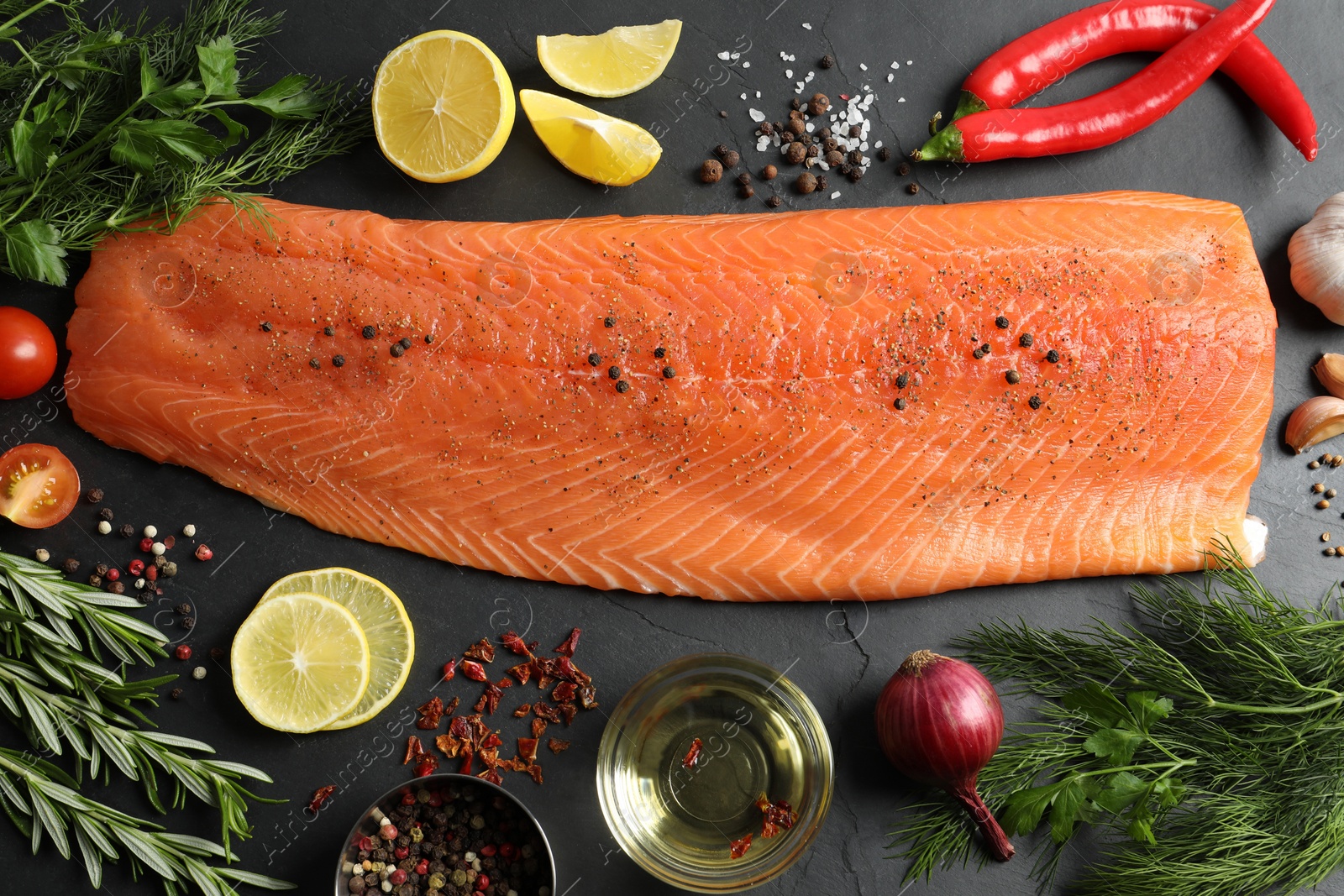 Photo of Fresh raw salmon and ingredients for marinade on black table, flat lay