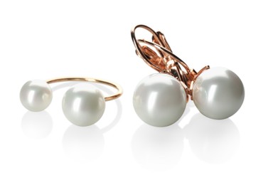 Photo of Elegant golden ring and earrings with pearls on white background