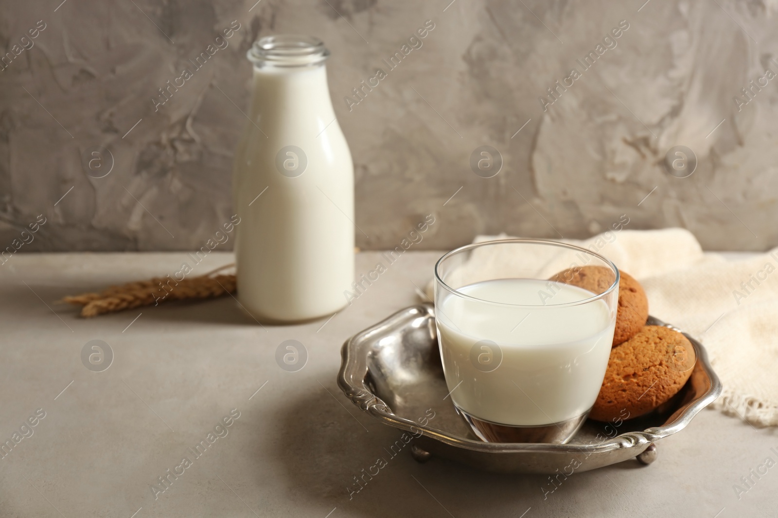 Photo of Glass with milk and biscuits on table