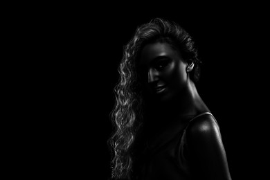 Silhouette of woman in darkness. Portrait on black background