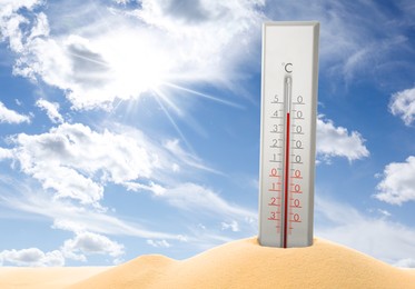 Image of Thermometer in sand showing high temperature during hot summer day