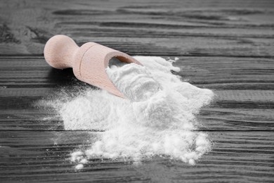 Scoop and fructose powder on dark wooden table