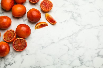 Photo of Many ripe sicilian oranges on white marble table, flat lay. Space for text