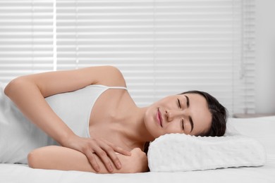 Woman sleeping on orthopedic pillow at home