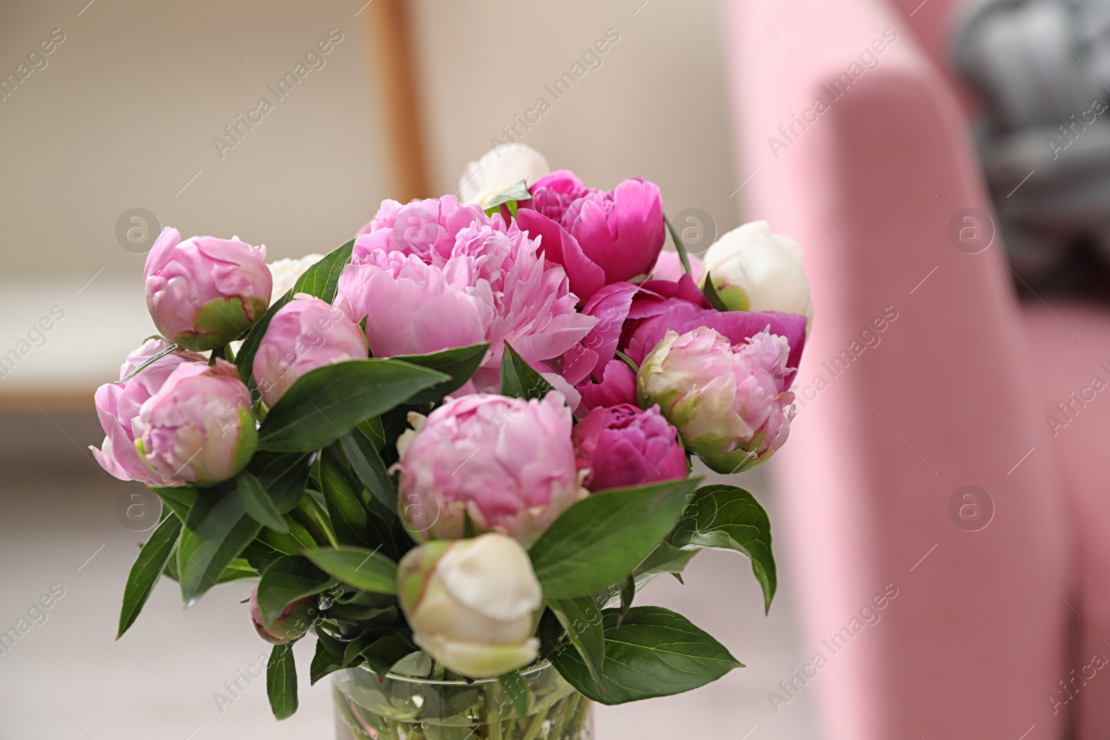 Photo of Vase with bouquet of beautiful peonies in room