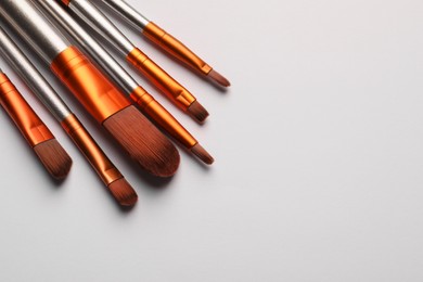 Photo of Set of makeup brushes on white background, space for text