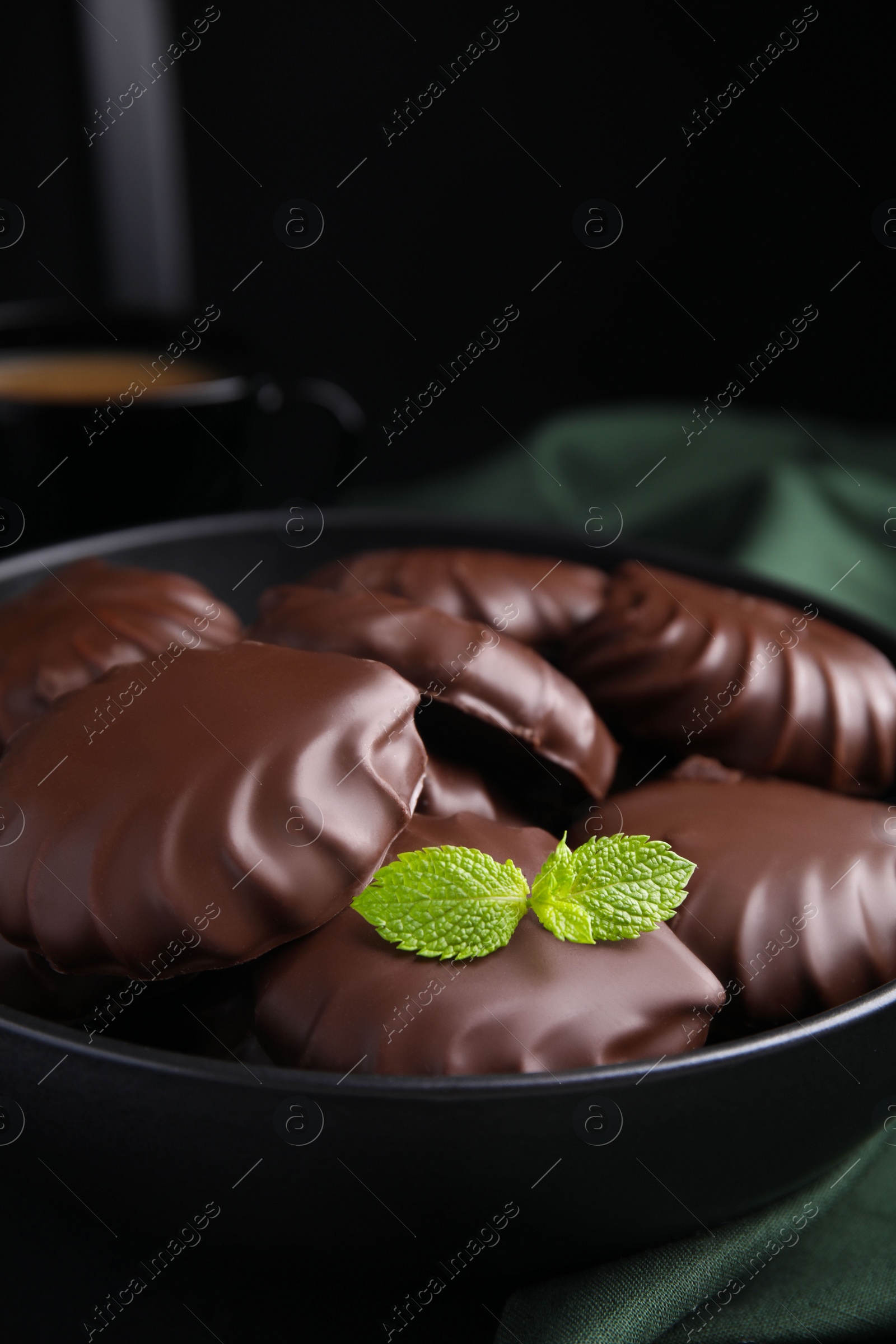 Photo of Delicious chocolate covered zephyrs with mint in bowl, closeup
