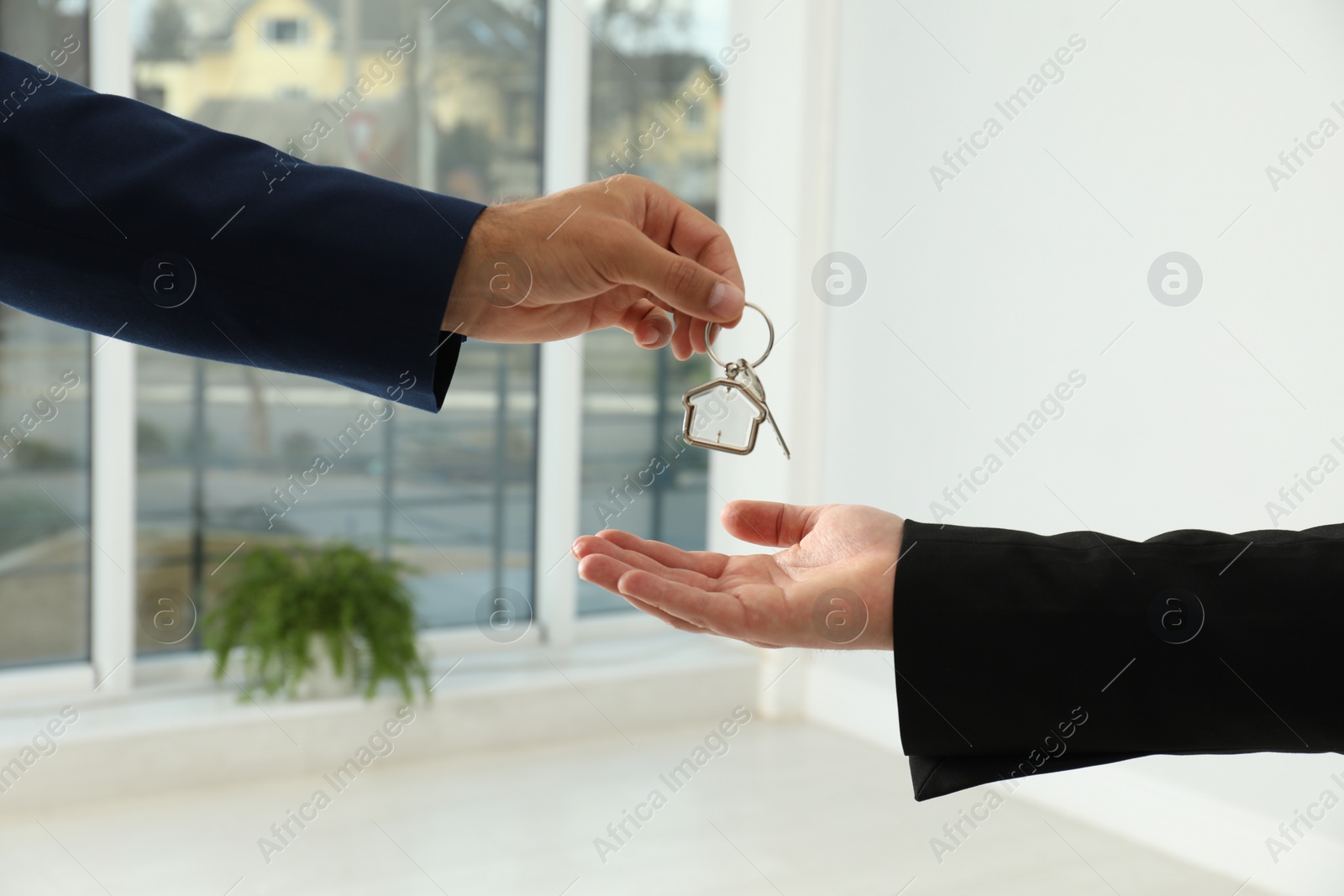 Photo of Real estate agent giving key to client in new house, closeup