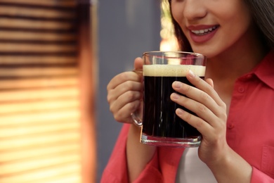 Young woman with cold kvass outdoors, closeup. Traditional Russian summer drink