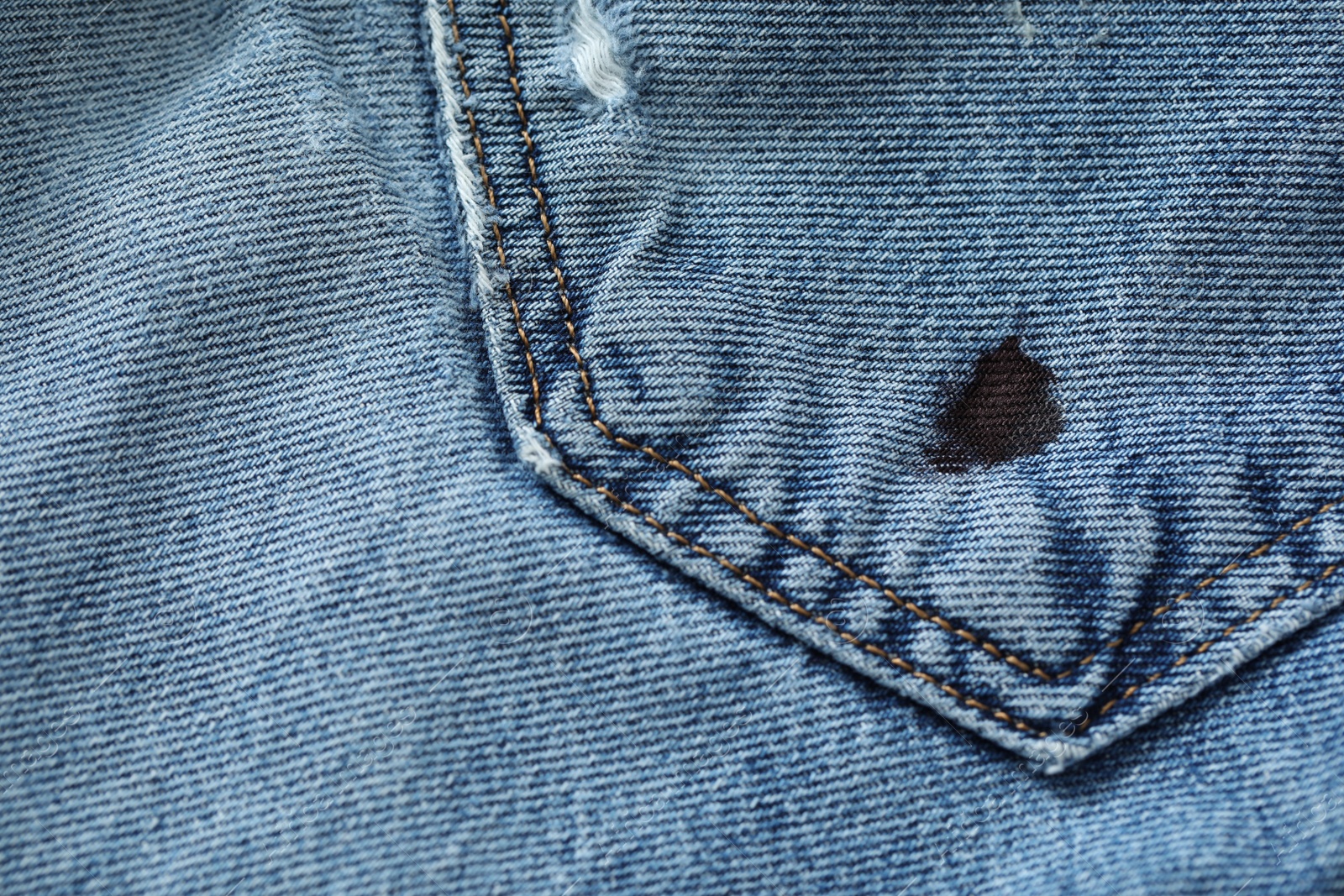 Photo of Stain of black ink on jeans, closeup. Space for text