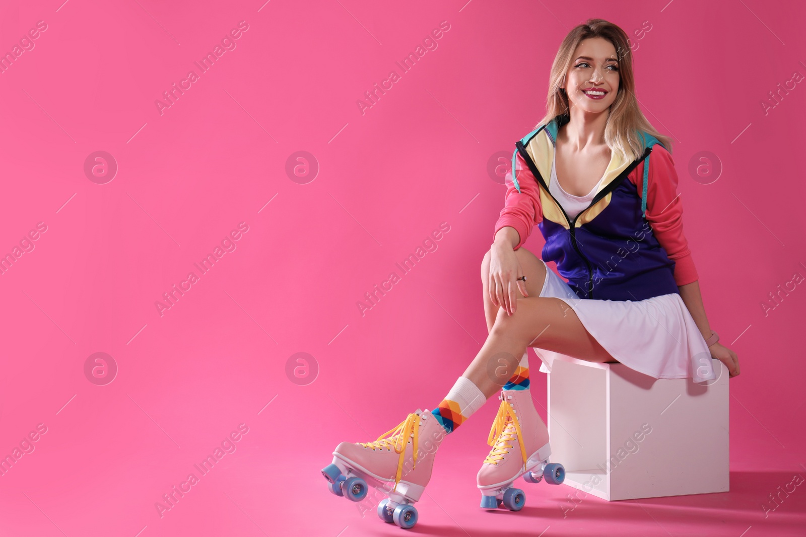 Photo of Young woman with retro roller skates on color background. Space for text