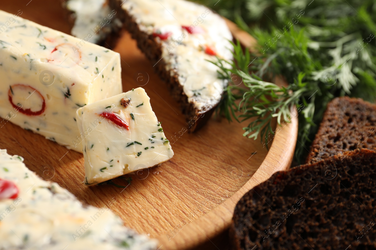 Photo of Tasty butter with dill, chili pepper and rye bread on table, closeup