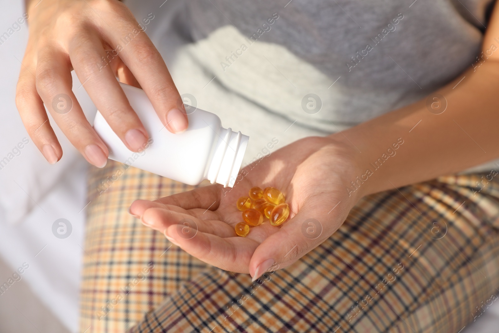 Photo of African-American woman with bottle of vitamin capsules, closeup