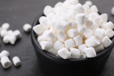Photo of Bowl with delicious marshmallows on black background, closeup