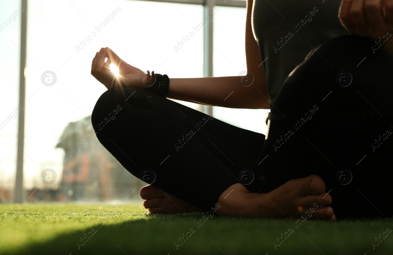 Photo of Young woman practicing yoga in sunlit room, closeup