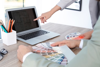 Photo of Team of designers working with color palettes at office table, closeup