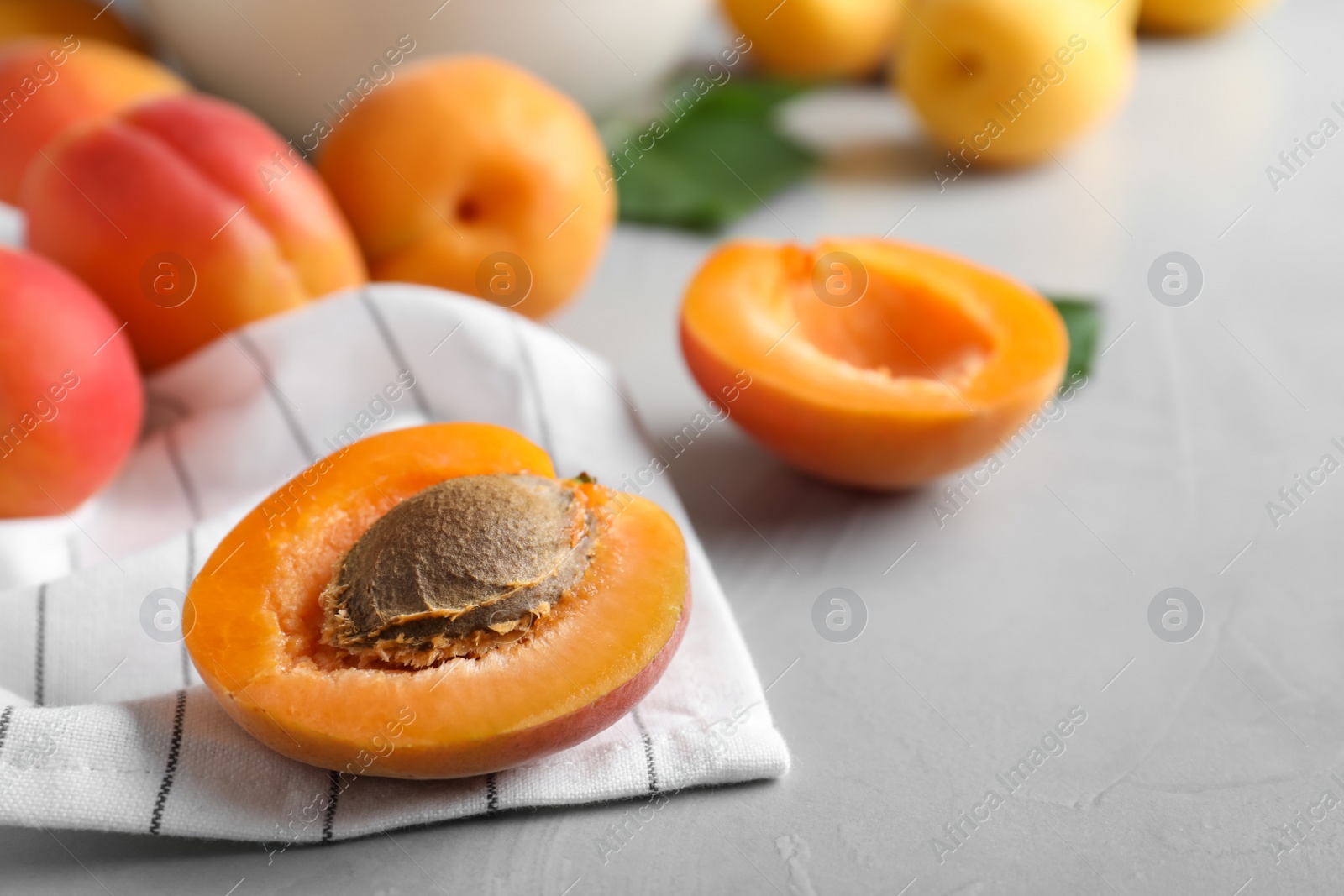 Photo of Fresh ripe apricots on light grey table. Space for text