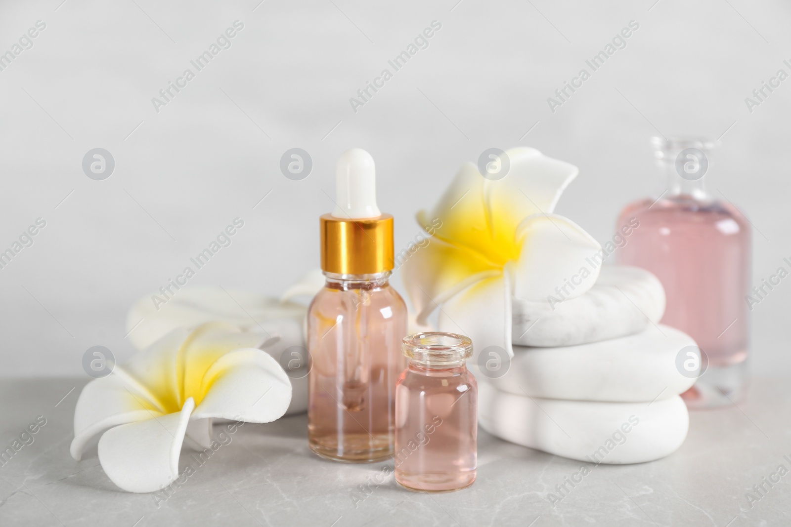 Photo of Beautiful composition with aroma oil and spa stones on marble table