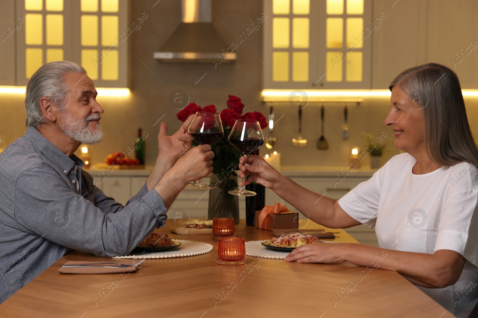 Photo of Affectionate senior couple having romantic dinner at home