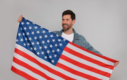 Photo of 4th of July - Independence Day of USA. Happy man with American flag on grey background