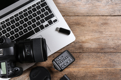 Photo of Flat lay composition with equipment for professional photographer on wooden table