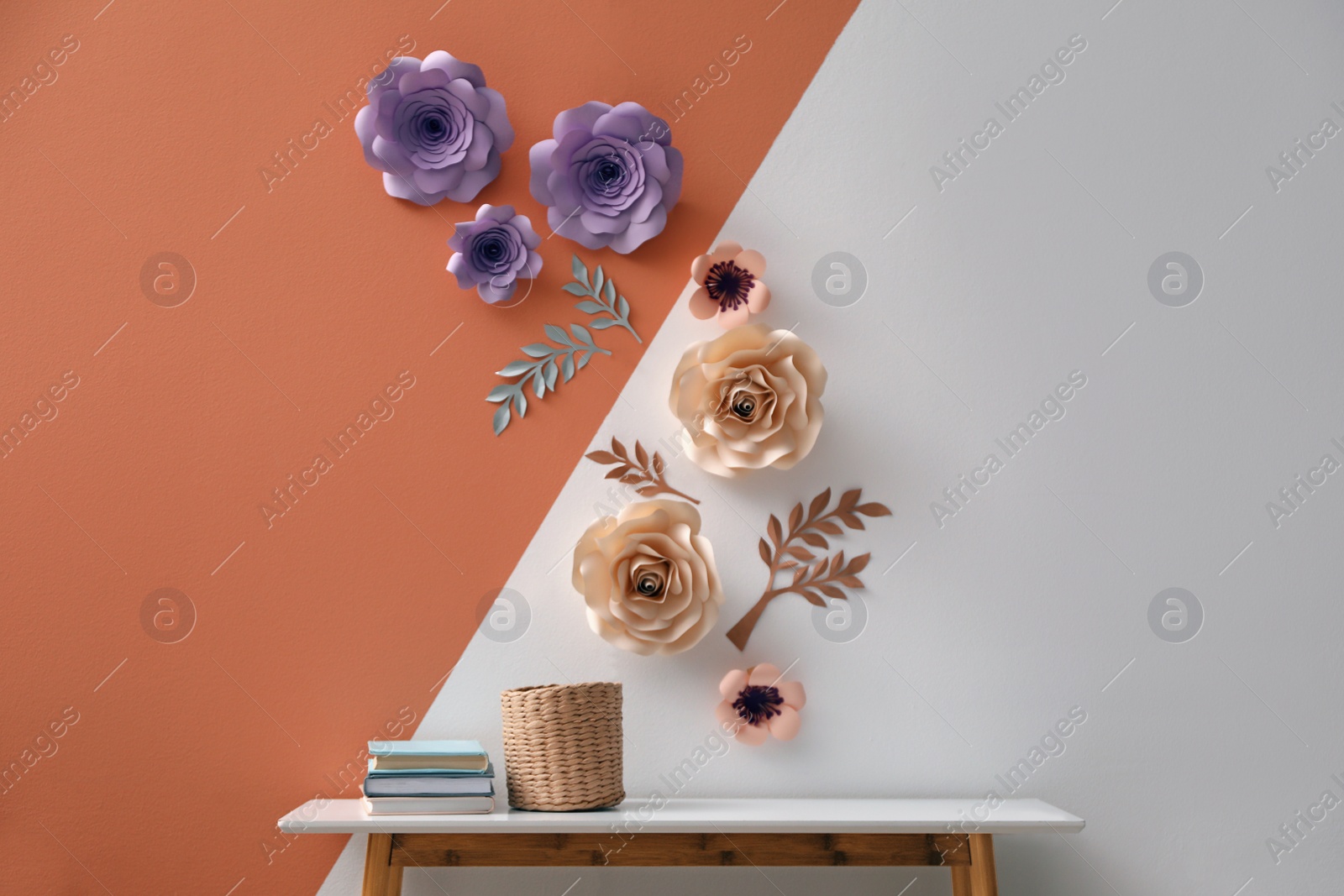Photo of Books and holder on table near color wall with floral decor